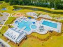 Aerial view of a community pool with lounge chairs, a water park area, a park and a pond at 285 Watersglen Dr, Summerville, SC 29486