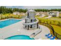 Community pool with slide, lap lanes, lounge chairs and mature landscaping at 289 Watersglen Dr, Summerville, SC 29486