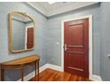 Charming hallway with a decorative table, ornate mirror, rich hardwood floors, and tasteful gray wallpaper at 341 Cooper River Dr, Mount Pleasant, SC 29464
