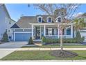 Charming two-story home with inviting porch, American flag, landscaped yard, and blue exterior paint at 3697 Stamler Ct, Mount Pleasant, SC 29466