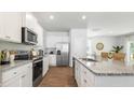 Bright kitchen featuring white cabinets, stainless steel appliances, and an island with granite countertops at 384 Willows Crescent Dr, Moncks Corner, SC 29461