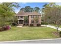 Beautiful brick home with a well-manicured lawn, mature trees, and a welcoming front entrance with double windows at 4217 Sawgrass Dr, Charleston, SC 29420