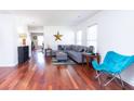 Bright living room featuring hardwood floors, large windows, and a comfortable gray sectional sofa at 5007 Ballantine Dr, Summerville, SC 29485