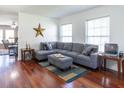 Bright living room featuring hardwood floors, large windows, and a comfortable gray sectional sofa at 5007 Ballantine Dr, Summerville, SC 29485