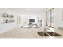 Bright, open concept kitchen with granite countertops, leading into a dining area and living room with ample natural light at 7027 Deanston Dr, Ravenel, SC 29470