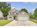 Charming two-story home with vinyl siding, a two-car garage, and a welcoming front porch with a decorative wreath at 708 Professor Dr, Ladson, SC 29456