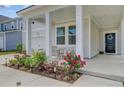 Inviting front porch with seating area and colorful landscaping, leading to a black front door at 86 Red Bluff St, Summerville, SC 29483
