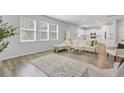 Bright, open-concept living room with hardwood floors, modern furnishings, and abundant natural light at 86 Red Bluff St, Summerville, SC 29483