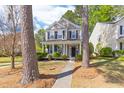 Inviting two-story home with a covered front porch, complemented by manicured landscaping and mature trees at 8961 N Red Maple Cir, Summerville, SC 29485