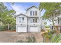 Charming two-story home with brick driveway, well-maintained lawn, and lush landscaping for curb appeal at 9 Marsh Island Ln, Isle of Palms, SC 29451