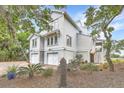 Striking two-story home featuring two-car garage, manicured landscaping, and charming curb appeal at 9 Marsh Island Ln, Isle of Palms, SC 29451