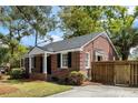 Charming brick home with side driveway and a wooden fence at 1 Colleton Dr, Charleston, SC 29407
