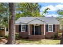 Charming brick home with black shutters and a manicured lawn at 1 Colleton Dr, Charleston, SC 29407