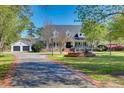 Beautiful white home with fountain, attached garage, and meticulously maintained landscaping at 1068 Witherbee Rd, Moncks Corner, SC 29461