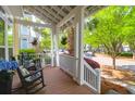 Inviting front porch featuring rocking chairs, hanging plants, and a view of the neighborhood at 1243 Appling Dr, Mount Pleasant, SC 29464