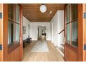 Grand foyer entrance featuring light hardwood floors, wooden ceiling and double wood doors with a view to the front porch at 1412 Jackson St, Mount Pleasant, SC 29464