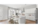 Bright, modern kitchen featuring a large island with seating, white cabinets, and stainless steel appliances at 1433 Clay Field Trl, Summerville, SC 29485