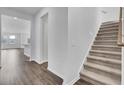 Welcoming entryway featuring hardwood floors, staircase, and an open view to the kitchen and living area at 145 Threaded Fern St, Summerville, SC 29485