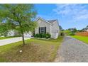 Well-maintained home with a landscaped yard, gravel driveway, and an attached garage at 161 Brittondale Rd, Summerville, SC 29485