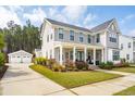 Beautifully landscaped home featuring a covered front porch, manicured lawn, and a detached two-car garage at 184 Clearblue Loop, Summerville, SC 29486