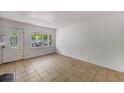 Bright living room with tile flooring, white walls, and a front door leading to the outside, capturing natural light at 203 Elliott Dr, Ladson, SC 29456