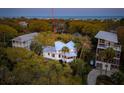 Aerial view of the home nestled among trees close to the coastline and neighboring houses at 217 E Huron Ave, Folly Beach, SC 29439
