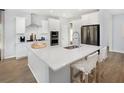 Modern kitchen featuring white cabinets, stainless steel appliances, a center island, and hardwood floors at 257 Camellia Bloom Dr, Moncks Corner, SC 29461
