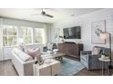 Cozy living room with modern furniture, shiplap accent wall, and ample natural light at 261 Camellia Bloom Dr, Moncks Corner, SC 29461