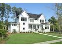Elegant two-story white home with manicured lawn, featuring black-trimmed windows at 2805 Stay Sail Way, Mount Pleasant, SC 29466