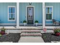 Inviting front porch with stylish decor and well-manicured landscaping details at 310 Ripple Park Dr, Summerville, SC 29486