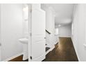 Hallway view featuring a pedestal sink in half bathroom with stylish door to adjacent staircase at 332 Long Pier St, Summerville, SC 29486