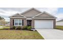 Well-maintained brick home featuring a two-car garage and tidy front yard at 369 Spruce Ivy St, Moncks Corner, SC 29461
