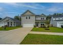 Inviting two-story home featuring a well-maintained lawn, attached garage, and welcoming front porch at 4314 Cotton Flt Rd, Summerville, SC 29485