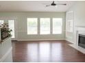Spacious living room with hardwood floors, fireplace, built-in shelving, and a ceiling fan at 518 Antebellum Ln, Mount Pleasant, SC 29464