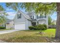 Attractive two-story home with a two-car garage, complemented by lush greenery and a mature tree at 5224 Stonewall Dr, Summerville, SC 29485