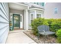Charming front entrance with a decorative door, a cozy bench, and mature shrubbery at 5224 Stonewall Dr, Summerville, SC 29485