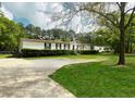 This single story home features a well-maintained lawn with mature trees with an extended driveway at 570 Crystal Shores Dr, Moncks Corner, SC 29461