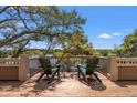 Relaxing deck with scenic waterfront views, featuring comfortable Adirondack chairs and beautiful trees at 66 New Settlement Rd, Kiawah Island, SC 29455