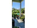 Relaxing porch view of a pool surrounded by lush tropical plants and vibrant flowers, creating a private oasis at 711 Farm Cottage Ln, Charleston, SC 29412