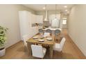 Bright and airy kitchen with white cabinetry, stainless steel appliances, a kitchen island, and a dining table at 7425 Indigo Palms Way, Johns Island, SC 29455