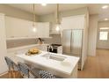 Modern kitchen with stainless steel appliances, white cabinetry, a subway tile backsplash, and a kitchen island at 7425 Indigo Palms Way, Johns Island, SC 29455