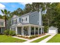Beautiful home with a covered front porch, inviting rocking chairs, and a detached garage at 8986 N Red Maple Cir, Summerville, SC 29485