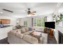 Bright living room with a fireplace, neutral decor, and a large window overlooking the backyard at 8986 N Red Maple Cir, Summerville, SC 29485