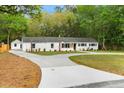 Beautiful exterior showcasing a white house, a long drive way and mature trees providing shade at 920 Julia St, Charleston, SC 29412