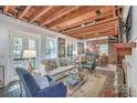 Cozy living room with exposed wood beams and fireplace with spiral staircase in view at 95 Ashley Ave # D, Charleston, SC 29401