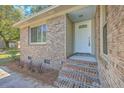 A welcoming front entrance with brick steps, a white door, and beautiful landscaping at 100 Lipman St, Summerville, SC 29483