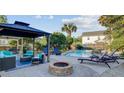 Backyard patio with a fire pit, cozy seating, and a view of the pool area at 101 Writing Ct, Ladson, SC 29456