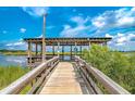 Picturesque wooden dock with covered structure over the water, showcasing serene waterfront views at 104 Tidewater Way, Charleston, SC 29492