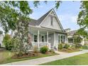 Beautifully landscaped home exterior with inviting front porch and meticulous yard at 113 Sugarberry Way, Summerville, SC 29485