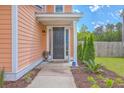 Inviting entryway with a dark-stained front door, manicured shrubs, and tidy landscaping at 120 Indigo Marsh Cir, Wando, SC 29492